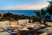 a table with food and wine glasses and the ocean at Swissôtel Living Bodrum in Bodrum City