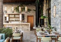 a restaurant with tables and chairs and a brick wall at Swissôtel Living Bodrum in Bodrum City