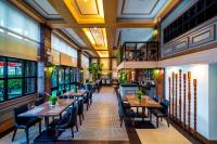 Un restaurante con mesas, sillas y ventanas. en The Isabelle Hotel, en Naga