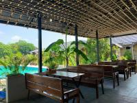 a restaurant with wooden tables and chairs and a pool at Rocky Mountain Ecolodge in Xuân Sơn