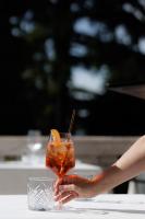 a person holding a drink on a table at Hotel Villa La Bollina in Serravalle Scrivia