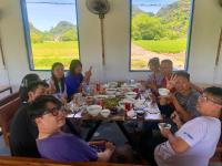 a group of people sitting around a table eating food at Rocky Mountain Ecolodge in Xuân Sơn