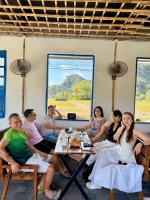 a group of people sitting around a table in a room at Rocky Mountain Ecolodge in Xuân Sơn