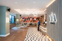 a woman standing in a store lobby with a mural at Via Antwerp in Antwerp