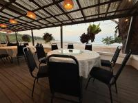 a restaurant with tables and chairs and a view of the ocean at Rafflesia Resort in Lundu