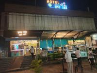 un grupo de personas de pie fuera de un hotel por la noche en The Jamun Tree, en Muzaffarpur