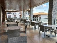 ein Esszimmer mit Tischen und Stühlen sowie ein Gebäude in der Unterkunft Pyrenéus Residence in Pirenópolis