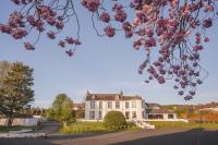 una gran casa blanca con flores rosas en primer plano en Torr House Hotel, en Dumfries