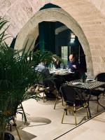 a group of people sitting at tables in a restaurant at Extra B&B in Trani