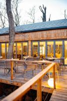 un restaurante con mesas y sillas en una terraza de madera en Pazar Homes, en Zánka