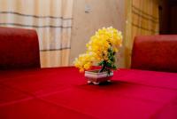 um vaso de flores amarelas sentado numa mesa vermelha em Aloha Hotel & Resort em Oshogbo