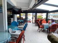 un ristorante con tavoli e sedie e una TV a schermo piatto di Apart Daire a Didim