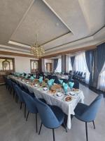 a long dining room with a long table and blue chairs at Hotel FAROHAT ONA in Khiva