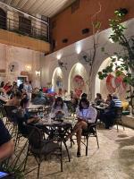 un grupo de personas sentadas en mesas en un restaurante en Empyrean Art Deco, en Santo Domingo