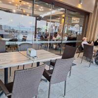 une table et des chaises dans un restaurant avec des gens qui mangent dans l'établissement Panoramic sea view at the beach, à Obzor
