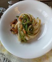 a white plate of pasta with mushrooms and greens at MEA DOMUS Mergellina in Naples