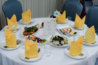 een tafel met borden vol eten en gele servetten bij Lailaresidence in Yala