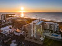 una vista aérea de la playa y del océano al atardecer en Sage Hotel Wollongong, en Wollongong