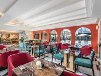 Un restaurante con sillas y mesas rojas y ventanas. en Pipa Hotel Bangkok Sukhumvit 11, en Bangkok