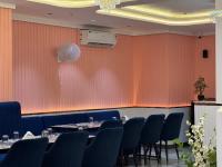 een eetkamer met tafels en stoelen en een muur bij C2 Hotel in Mathura