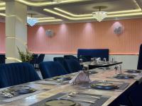 een eetkamer met een lange tafel en blauwe stoelen bij C2 Hotel in Mathura