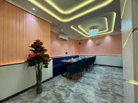 een restaurant met een lange tafel met stoelen en een bloem bij C2 Hotel in Mathura