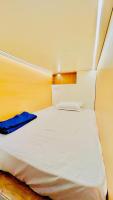 1 dormitorio con cama blanca y manta azul en LF Easybeds, en Kozhikode