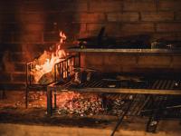 a fire in a brick fireplace with a bench in front at Lodge Mondo in Nishina