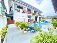 a patio with chairs and an umbrella and a pool at Luang Prabang Pavilion Hotel &amp; Travel in Luang Prabang