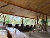 a dining area with a large wooden table and chairs at The Munduk Camp in Munduk
