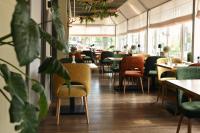 a restaurant with tables and chairs and plants at Hotel Medemblik in Medemblik