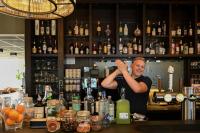 a man standing behind a bar with his hand in the air at Hotel Medemblik in Medemblik