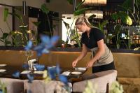 a woman in a restaurant preparing food on a table at Hotel Medemblik in Medemblik