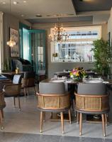 un ristorante con tavoli e sedie e un lampadario di RUKA Hotel a Narlıdere