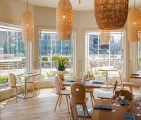 ein Esszimmer mit Tischen, Stühlen und Fenstern in der Unterkunft The Stonebreaker Hotel in Fayetteville