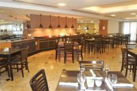 Un restaurante con mesas y sillas y un bar. en FLAT 1805 - SOL Alphaville Hotel e Residence Barueri, en Barueri