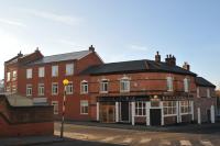 un gran edificio de ladrillo rojo en la esquina de una calle en Royal George Hotel, en Birmingham