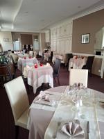 ein Esszimmer mit weißen Tischen und weißen Stühlen in der Unterkunft Logis Hôtel & Restaurant de la Barque in Beaumont-sur-Sarthe