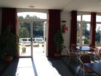 a restaurant with tables and chairs and a sliding glass door at Hotel San Jorge in Alcalá de los Gazules