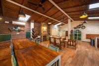 un ampio soggiorno con un grande tavolo in legno di Echor Malusara Lakeview Retreat Bhimtal a Bhimtal