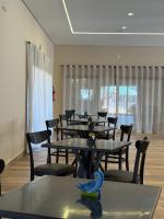 a row of tables and chairs in a room at Pousada Maritaca in Bonito