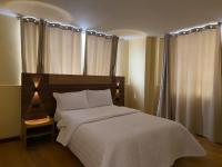 Un dormitorio con una cama con una colcha blanca. en Hotel Suyusama, en Ipiales