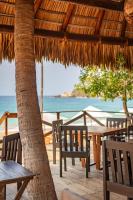a table and chairs under a straw umbrella on the beach at Casa Lu Hotel Boutique in Mazunte