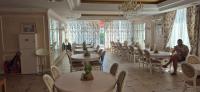 een restaurant met tafels en stoelen en een persoon die op een stoel zit bij Apartment Sofia Macon Residence Sveti Vlas in Sveti Vlas