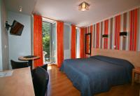 a bedroom with a bed and a table and a window at Hôtel Panoramic in Luchon