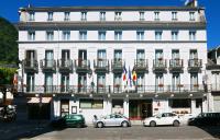 a large white building with cars parked in front of it at Hôtel Panoramic in Luchon