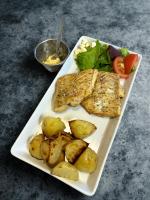 Un plato de comida con pescado y patatas y una ensalada. en Guesthouse Stöng and Cottages, en Stöng