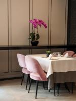 Una mesa con sillas rosas y un jarrón con flores rosas. en Grand Park City Hall, en Singapur