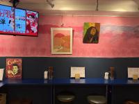 a blue counter in a restaurant with posters on the wall at Pagi Hotel in Tokyo