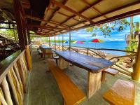 een houten bankje op het strand met uitzicht op de oceaan bij Jala Beach Resort in Villalimpia